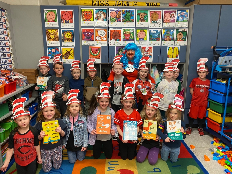 people dressed in hats and wigs and holding books